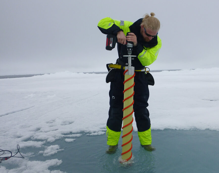 Researcher uses a Kovacs ice coring drill to take an ice core sample