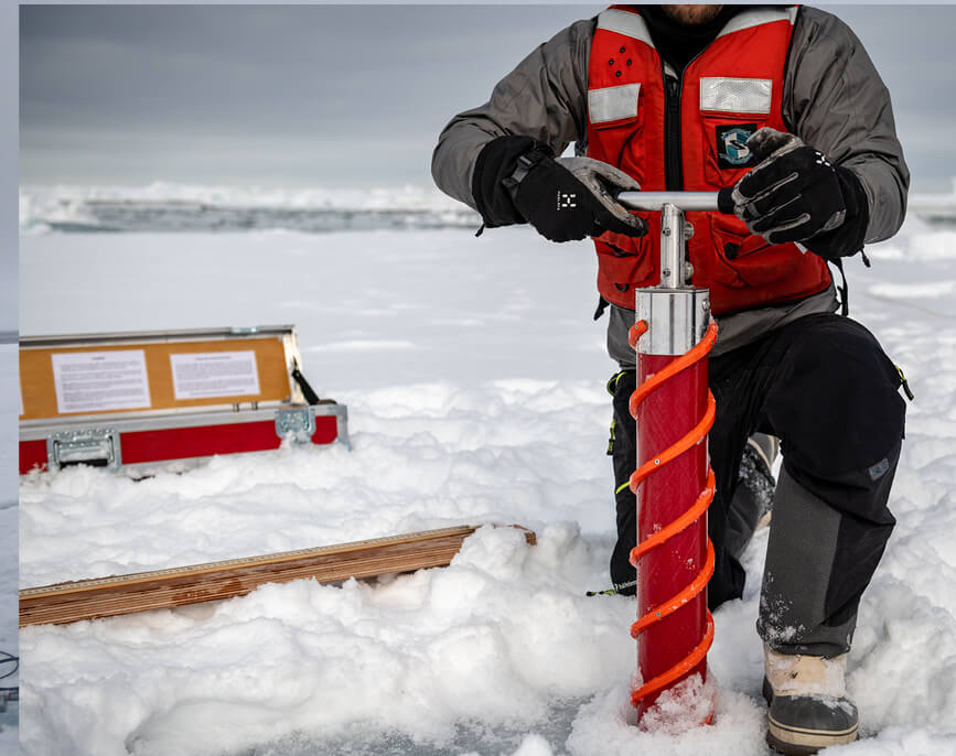 Researcher uses a Kovacs ice coring drill with T handle to take ice core sample